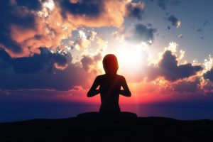 3D render of a female in a yoga pose against a sunset sky